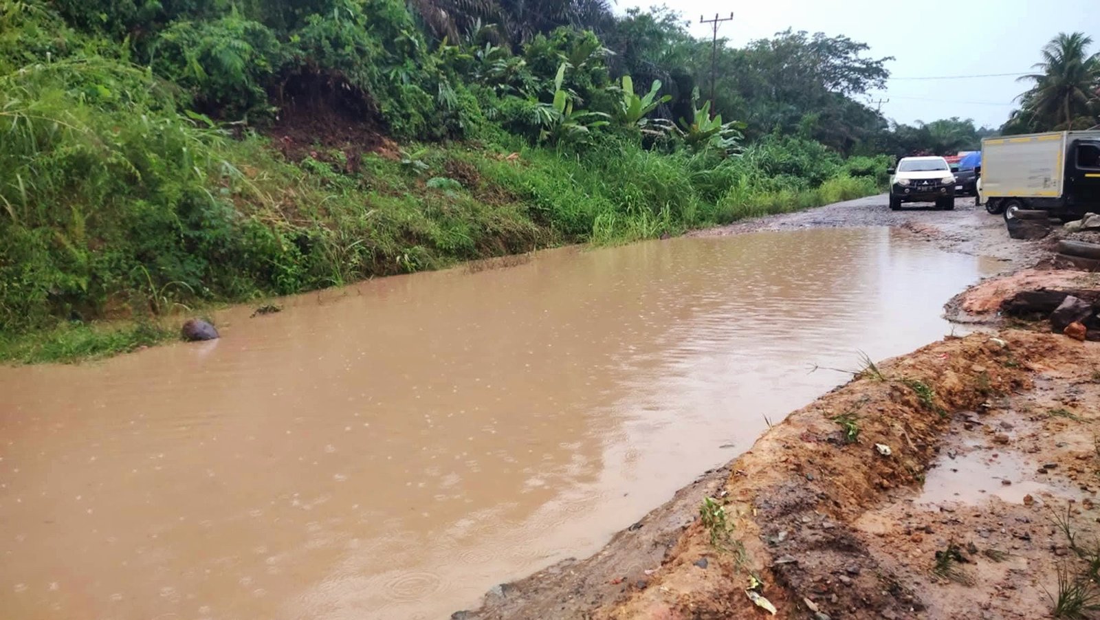 Kondisi Jalan yang rusak parah dan terdapat genangan air yang sangat besar, menyulitkan pengendara yang melintas pada Rabu (13/8/2025).