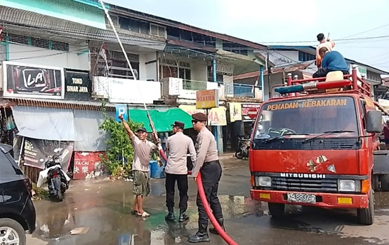 Antisipasi Cuaca Panas, Petugas Semprot Ruko Pasar Lawang Kuari