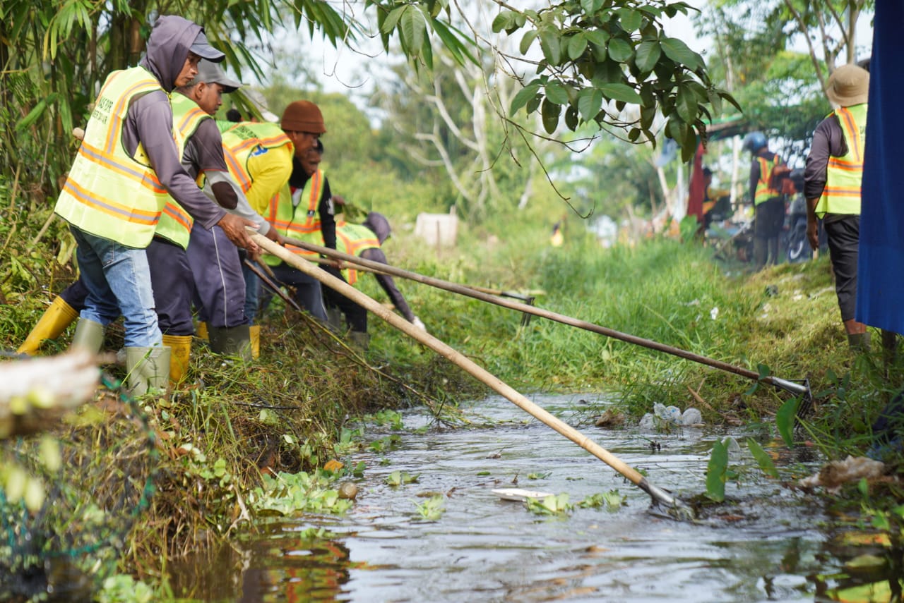 Petugas membersihkan dan menormalisasi parit dalam upaya mengatasi genangan air. Langkah ini merupakan bagian dari program prioritas 100 hari kerja Wali Kota Pontianak, Edi Rusdi Kamtono, dalam meningkatkan sistem drainase kota.