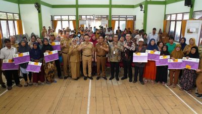 Foto menunjukkan Wali Kota Pontianak, Edi Rusdi Kamtono, bersama pejabat pemerintah dan warga penerima manfaat dalam acara penyerahan Bantuan Sosial Tunai (Bansos Tunai) di Aula Kantor Kecamatan Pontianak Barat pada 11 Maret 2025. Warga memegang papan simbolis penerimaan bantuan dengan suasana penuh keakraban.