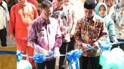 Foto memperlihatkan Wali Kota Pontianak Edi Rusdi Kamtono dan Wakil Wali Kota Bahasan memotong pita berwarna biru dalam acara peresmian fasilitas kesehatan. Mereka mengenakan pakaian batik, dikelilingi oleh beberapa pejabat dan tamu undangan. Balon berwarna hijau terlihat di sekitar area peresmian.