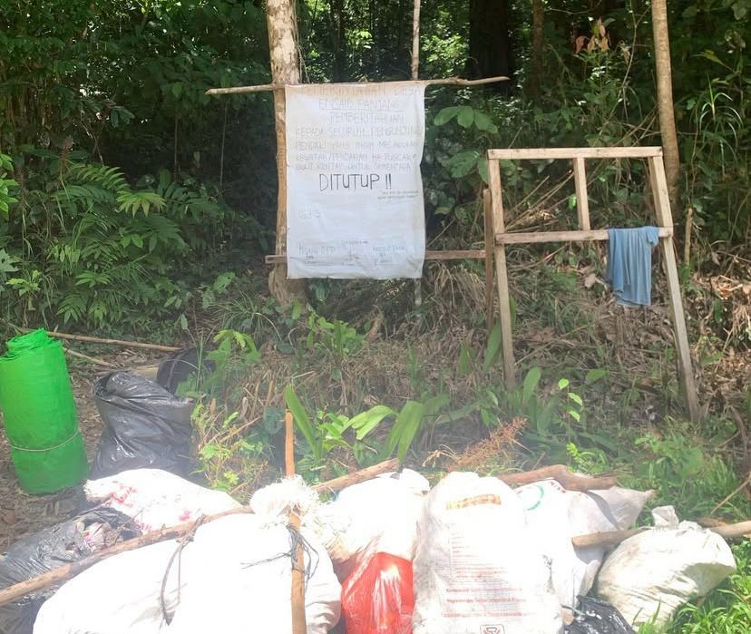 Papan pemberitahuan akses pendakian ke bukit rentap ditutup. Terlihat banyaknya sampah yang menumpuk di depan papan tersebut.