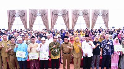 Foto bersama Wakil Wali Kota Pontianak Bahasan dan ratusan guru ngaji tradisional di Aula Rumah Jabatan Wali Kota. Beberapa guru memegang papan bertuliskan bantuan operasional Rp1,8 juta.