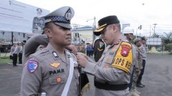 Kapolres Ketapang AKBP Setiadi memasangkan pita tanda operasi kepada anggota kepolisian dalam Apel Gelar Pasukan Operasi Ketupat Kapuas 2025, disaksikan oleh personel gabungan dari TNI, Satpol PP, dan instansi terkait.