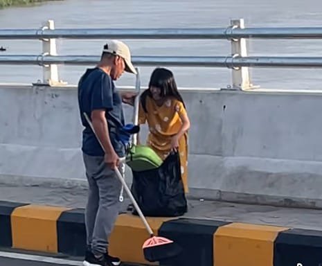 Terlihat bapak dan anak sedang membersihkan sampah di area JSSB, Kamis (3/4/2025). (screencapture video @rudi).