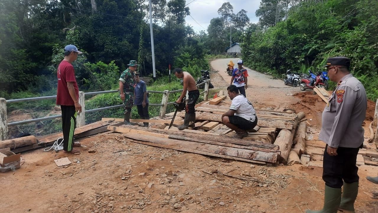Kapolsek Sayan beserta Danramil dan warga setempa saat memperbaiki Jembatan Sungai Kenoka. Sabtu (19/4/2025). Foto: Polres Melawi/Faktakalbar.id