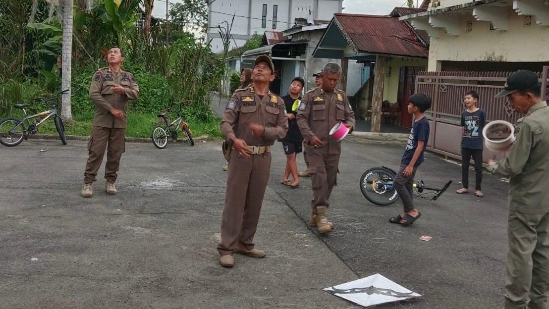 Petugas Satpol PP Pontianak saat menertibkan warga yang kedapatan bermain layangan di area jalan umum. Foto: HO/Faktakalbar.id
