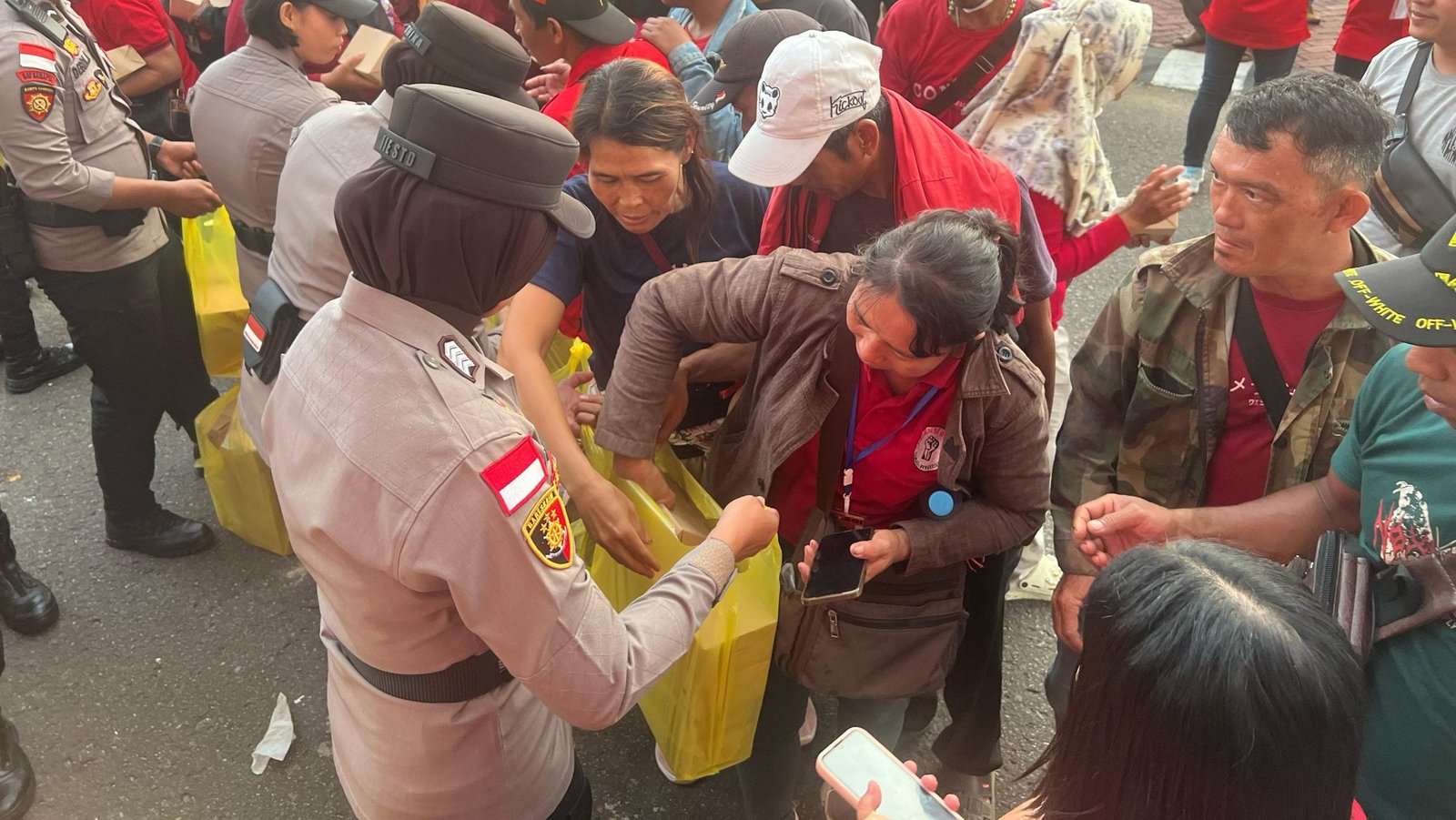 Anggota polisi membagikan nasi kotak kepada peserta aksi May Day di Sambas sebagai bentuk kepedulian di tengah demonstrasi. Foto: HO/Faktakalbar.id