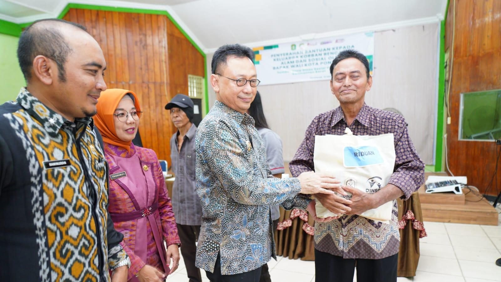 Wali Kota Pontianak Edi Rusdi Kamtono menyerahkan bantuan secara simbolis kepada warga korban bencana alam dan sosial di Aula Kantor Camat Pontianak Barat. Foto: HO/Faktakalbar.id