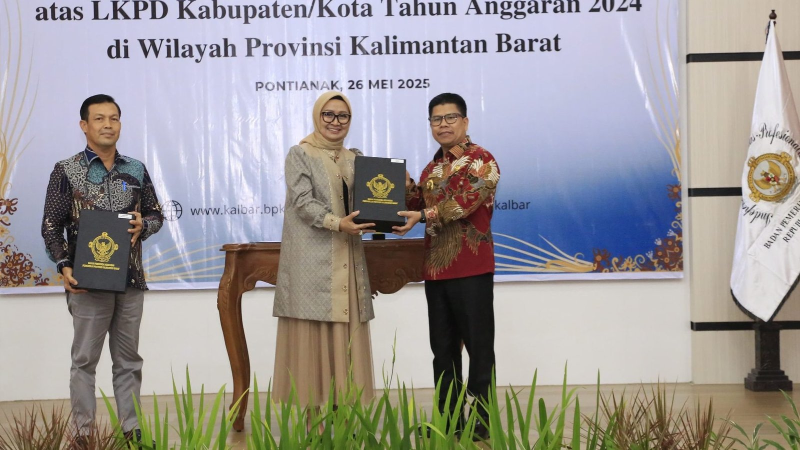 Bupati Sambas Satono menerima penghargaan opini WTP ke-7 dari Kepala BPK RI Perwakilan Kalbar, Sri Haryati, di Aula BPK RI Kalbar, Senin (26/05/2025). Foto: HO/Faktakalbar.id