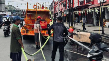 Armada pemadam dari BPKS Sambas menyemprotkan air untuk membersihkan area pasar yang sulit dijangkau. (Dok. Ist)