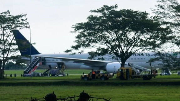 Pesawat Saudia Airlines SV 5276 terlihat terparkir di area isolasi Bandara Kualanamu, Selasa (17/6), setelah melakukan pendaratan darurat akibat ancaman bom. Tim keamanan gabungan masih berjaga di sekitar pesawat untuk memastikan situasi aman. (Dok. Ist)