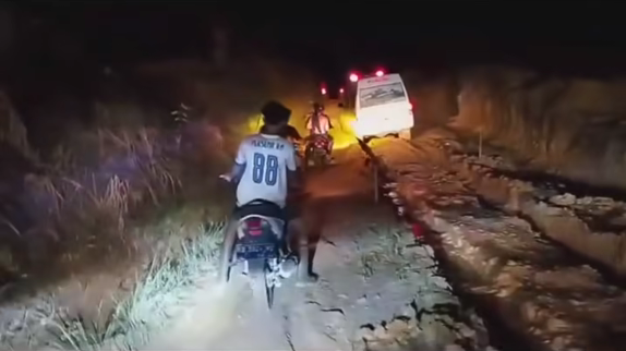 Sebuah ambulans tampak kesulitan melintas di jalan rusak kawasan Bindang, Tempunak Hulu, Kabupaten Sintang. (Sumber: Facebook)