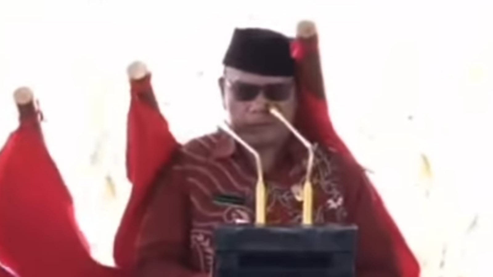 Foto: Detik-detik Ketua Kantor Urusan Agama (KUA) Kecamatan Sanggau Ledo, Imam Subakir, tertimpa bendera saat tengah membacakan doa di atas panggung. (Dok. Tangkapan layar)