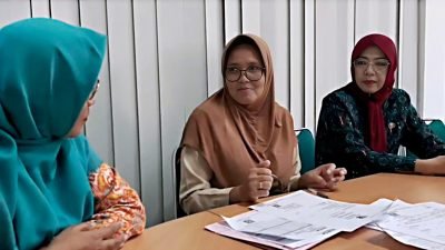 Wiwik (tengah) saat berkunjung ke Disdukcapil Kota Pontianak untuk mencetak akta kematian almarhumah ibunya. Proses penerbitan akta kematian selesai dalam sehari dan dikirim melalui email yang terdaftar. Foto: HO/Faktakalbar.id