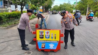 Petugas Polsek Pontianak Selatan bersama Damkar Kota Pontianak membersihkan tumpahan oli usai kejadian kecelakaan motor tunggal di Jalan Jenderal Ahmad Yani, Minggu (22/6/2025). Foto: HO/Faktakalbar.id