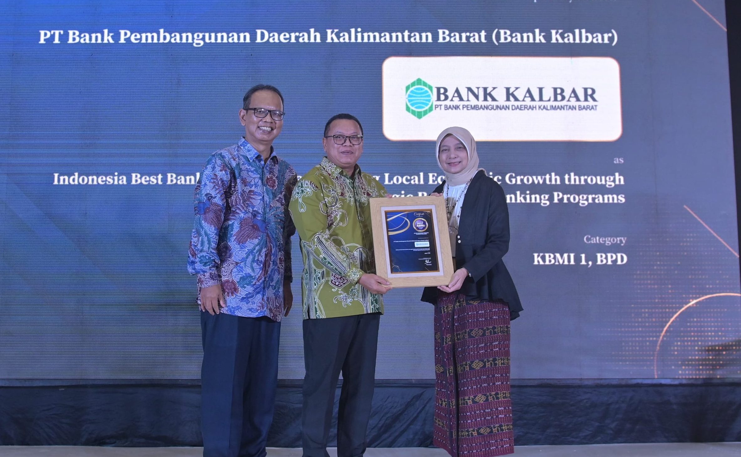 Direktur Utama Bank Kalbar, Rokidi (tengah), menerima penghargaan Indonesia Best Bank 2025 dari Warta Ekonomi atas komitmen penguatan ekonomi lokal, didampingi perwakilan Warta Ekonomi.