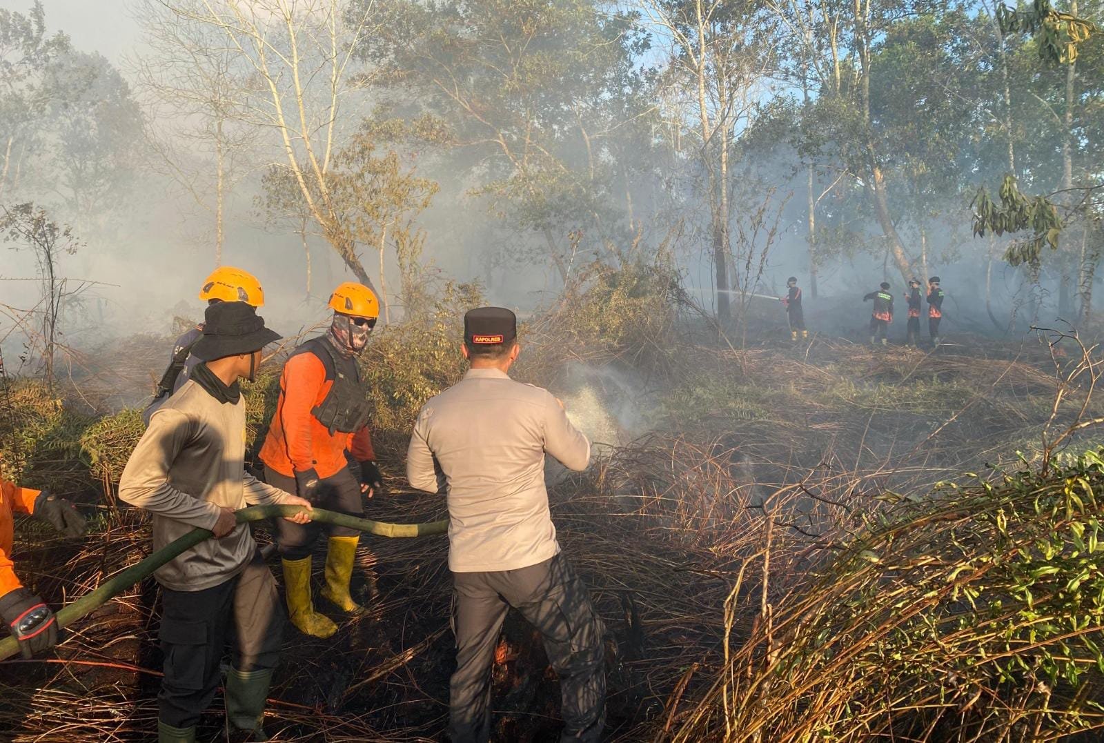 Pembasahan lahan dilakukan untuk mencegah api meluas ke area pemukiman usai terjadi karhutla di wilayah Desa Rasau Jaya Umum, Kamis (27/6/2025) (dok. Polres Kubu Raya)