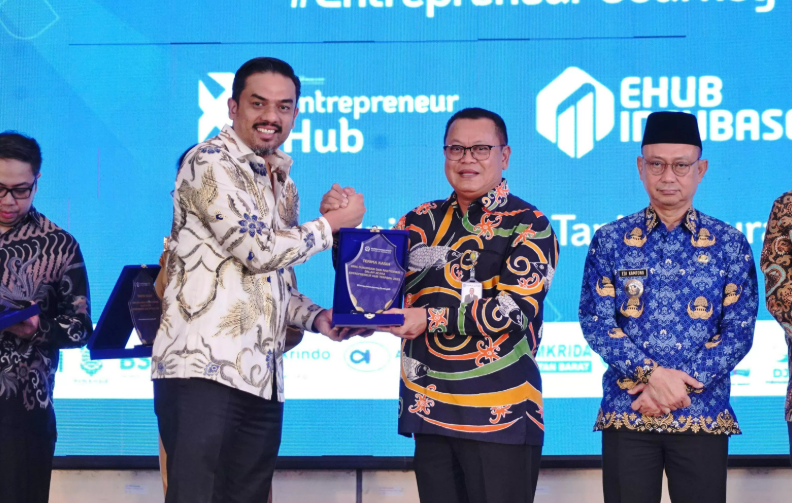 Menteri UMKM Maman Abdurrahman menyerahkan penghargaan kepada Direktur Utama Bank Kalbar, Rokidi, atas kontribusi Bank Kalbar dalam mendukung UMKM pada kegiatan Entrepreneur Hub Terpadu Kalimantan Barat 2025, Senin (2/6/2025). (Dok. Bank Kalbar)