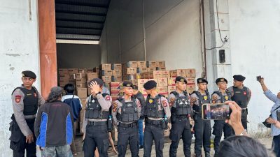 Penyidik Ditreskrimsus Polda Kalbar membuka pintu gudang oli diduga palsu di Kubu Raya, dijaga ketat oleh aparat kepolisian saat olah TKP. (Dok. Faktakalbar.id)