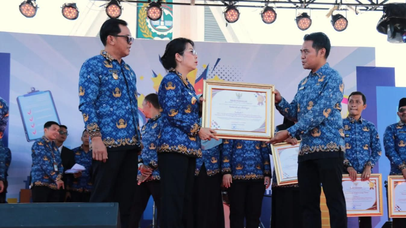 Tjhai Chui Mie menyerahkan piagam penghargaan kepada Camat Singkawang Barat sebagai penerima Predikat Terbaik I realisasi PBB-P2 Tahun 2024. (Dok. Kec. Singkawang Barat)