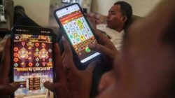 Ilustrasi - Seorang tengah mengakses situs judi online melalui ponsel di tengah aktivitas sehari-hari. PPATK mencatat lebih dari 500 ribu penerima bansos terindikasi bermain judi online sepanjang 2024. (Dok. Ist)