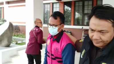 "Sekretaris Desa Cipaku berinisial MGS digelandang petugas Kejari Majalengka menuju mobil seusai ditetapkan sebagai tersangka kasus korupsi dana desa senilai Rp 513 juta, Kamis, 3 Juli 2025"