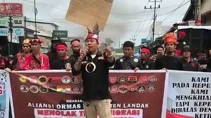 Suasana aksi damai Aliansi 28 Ormas di Simpang Tiga Jalan Raya Dusun Pulau Bendu, Kecamatan Ngabang, yang menyuarakan penolakan terhadap program transmigrasi pemerintah pusat, Jumat (18/7/2025). (Dok. Ist)