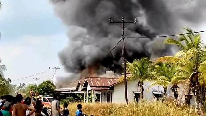 Kepulan asap tebal membubung ke langit saat api melalap dua rumah warga dalam peristiwa kebakaran di Segedong, Mempawah, Kamis siang (24/7/2025).