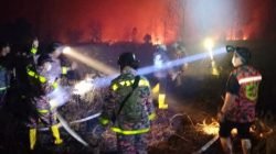 Petugas pemadam kebakaran berjibaku memadamkan api yang melanda lahan di sekitar jalur utama menuju Bandara Singkawang, Senin (28/7/2025) malam.