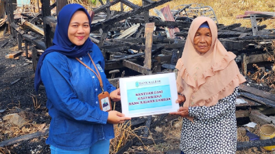 Pegawai Bank Kalbar saat menyerahkan bantuan kepada Ibu Zainab, guru ngaji yang rumahnya terbakar di Desa Penakalan, Kecamatan Sejangkung, Kabupaten Sambas. Foto: HO/Faktakalbar.id