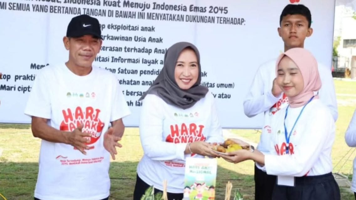 Wakil Bupati Ketapang, Jamhuri Amir, secara simbolis memberikan potongan tumpeng kepada dengan salah satu anak.