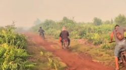 Sejumlah warga menggunakan sepeda motor melintasi jalan tanah menuju lokasi kebakaran lahan di Kecamatan Teluk Keramat, Kabupaten Sambas. (Dok. Ist)