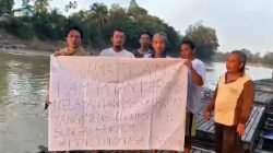 "Sejumlah petani keramba dan masyarakat membentangkan spanduk di atas rakit di Sungai Sekadau. Spanduk tersebut berisi seruan untuk menyelamatkan mereka dari dampak pencemaran sungai yang diduga akibat limbah penambangan emas tanpa izin (PETI), yang telah merugikan mata pencaharian dan mengancam sumber air konsumsi warga.