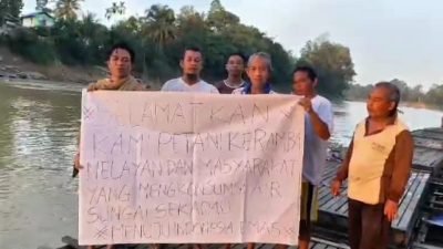 "Sejumlah petani keramba dan masyarakat membentangkan spanduk di atas rakit di Sungai Sekadau. Spanduk tersebut berisi seruan untuk menyelamatkan mereka dari dampak pencemaran sungai yang diduga akibat limbah penambangan emas tanpa izin (PETI), yang telah merugikan mata pencaharian dan mengancam sumber air konsumsi warga.