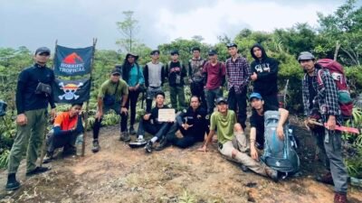 Tim pendaki berpose bersama di puncak Gunung Rumput, merayakan keberhasilan menaklukkan atap tertinggi Kabupaten Sambas di perbatasan Indonesia-Malaysia.