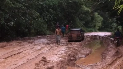 Kondisi jalan menuju arah Tanjung–Marau, khususnya di wilayah Kecamatan Jelai Hulu, terlihat juga terdapat mobil yang kecil yang tersangkut di kubangan lumpur pada jalan tersebut. Foto: Facebook/Aga Pardela