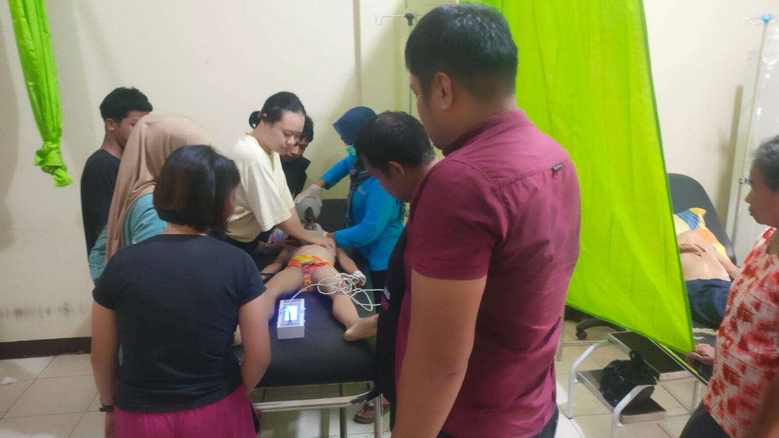 Tim medis dan keluarga berada di sekitar tubuh seorang anak yang terbaring di ranjang periksa, setelah insiden tenggelam di Sungai Sekayam. Foto: HO/Faktakalbar.id