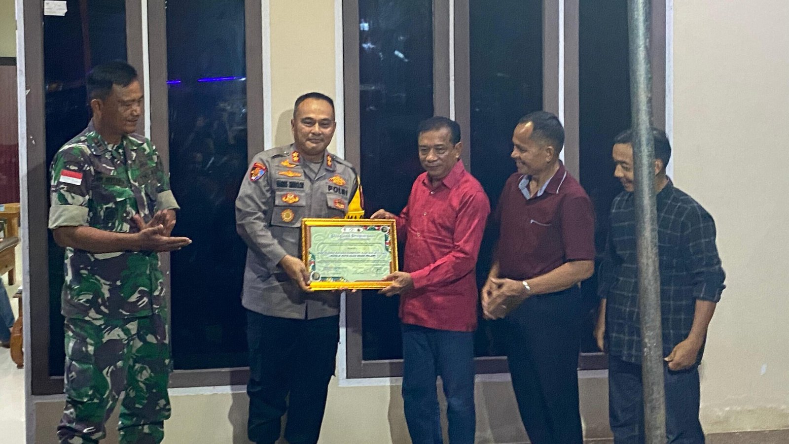 Kapolres Melawi AKBP Harris Batara Simbolon saat menerima piagam penghargaan dari Ketua DAD Melawi Kluisen dan Ketua Panitia Yamin dalam acara syukuran dan pembubaran panitia Gawai Dayak XVII Melawi, Rabu (27/8/2025). Foto: HO/Faktakalbar.id