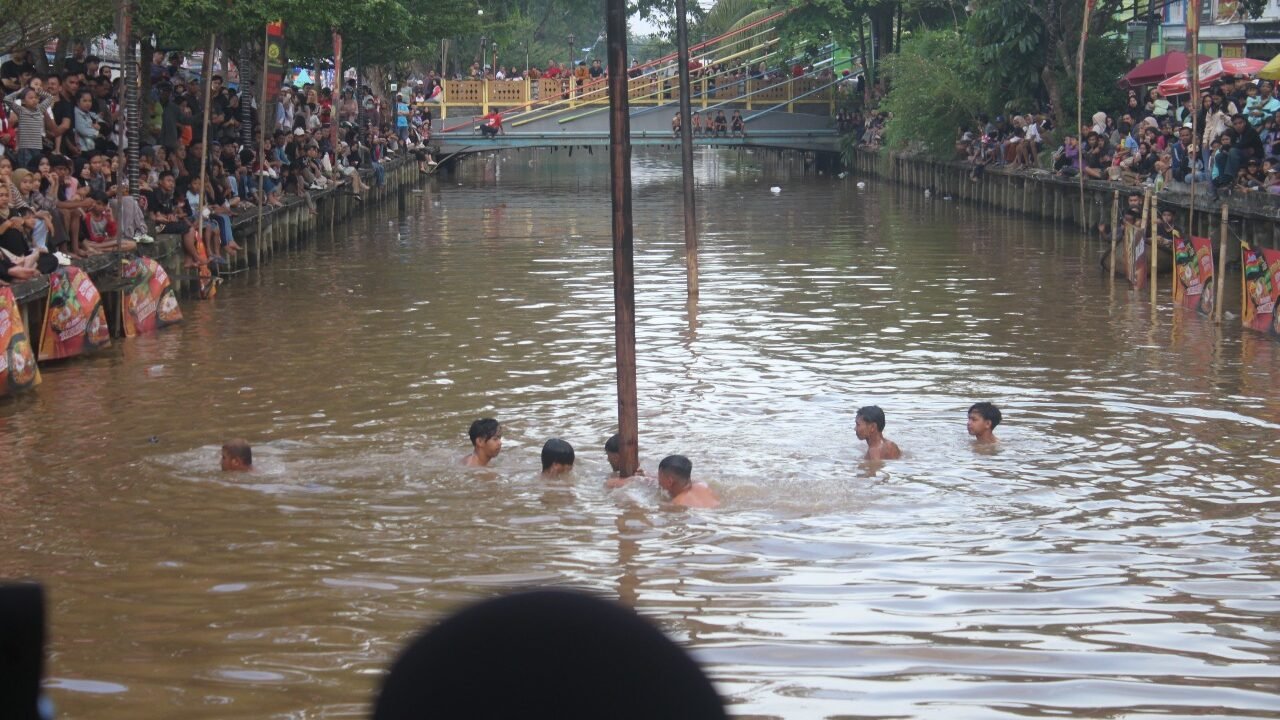 Para peserta dengan antusias mengikuti perlombaan di atas air yang disaksikan oleh ratusan warga di tepi Sungai Jawi Dalam, Pontianak.