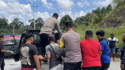 Petugas kepolisian saat melakukan proses evakuasi jenazah YB (39) yang ditemukan di tepi Jalan Lintas Malenggang, Kecamatan Sekayam, Senin (18/8/2025).