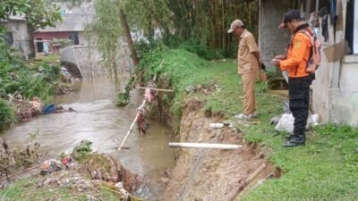 Petugas meninjau dan mendata dampak longsor yang terjadi di Kecamatan Bojonggede, Kabupaten Bogor, Senin (11/8).
