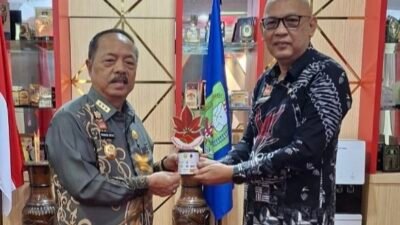 Plt. Kepala Bapperida Sanggau, Shopiar Juliansyah (kiri), saat menyerahkan laporan kegiatan dan plakat Sabang Merah Berdompu kepada Bupati Sanggau di ruang kerjanya, Kamis (21/8/2025).