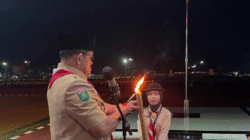 Umaira menerima obor yang dinyalakan Wakil Bupati Sambas sebagai tanda dimulainya Pawai Obor Ulang Janji Pramuka. (Dok. Ist)