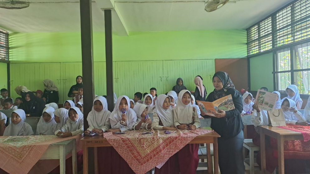 Peserta didik SDN 20 Ketapang tampak antusias membaca nyaring buku tentang literasi iklim dalam kegiatan bersama TBM Sahabat Cita Khatulistiwa dan mahasiswa UKM Seni Budaya. (Dok. Faktakalbar.id)