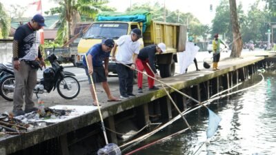 Sekretaris Daerah Kota Pontianak, Amirullah (tengah), bersama warga dan petugas gabungan saat melakukan aksi gotong royong membersihkan parit di Jalan Alianyang sebagai bagian dari upaya pengelolaan sampah di Pontianak, Minggu (10/8/2025).