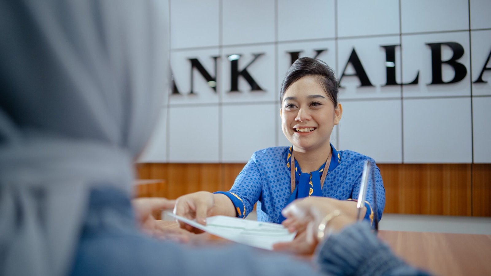 Seorang Teller Bank Kalbar tengah melayani nasabah.