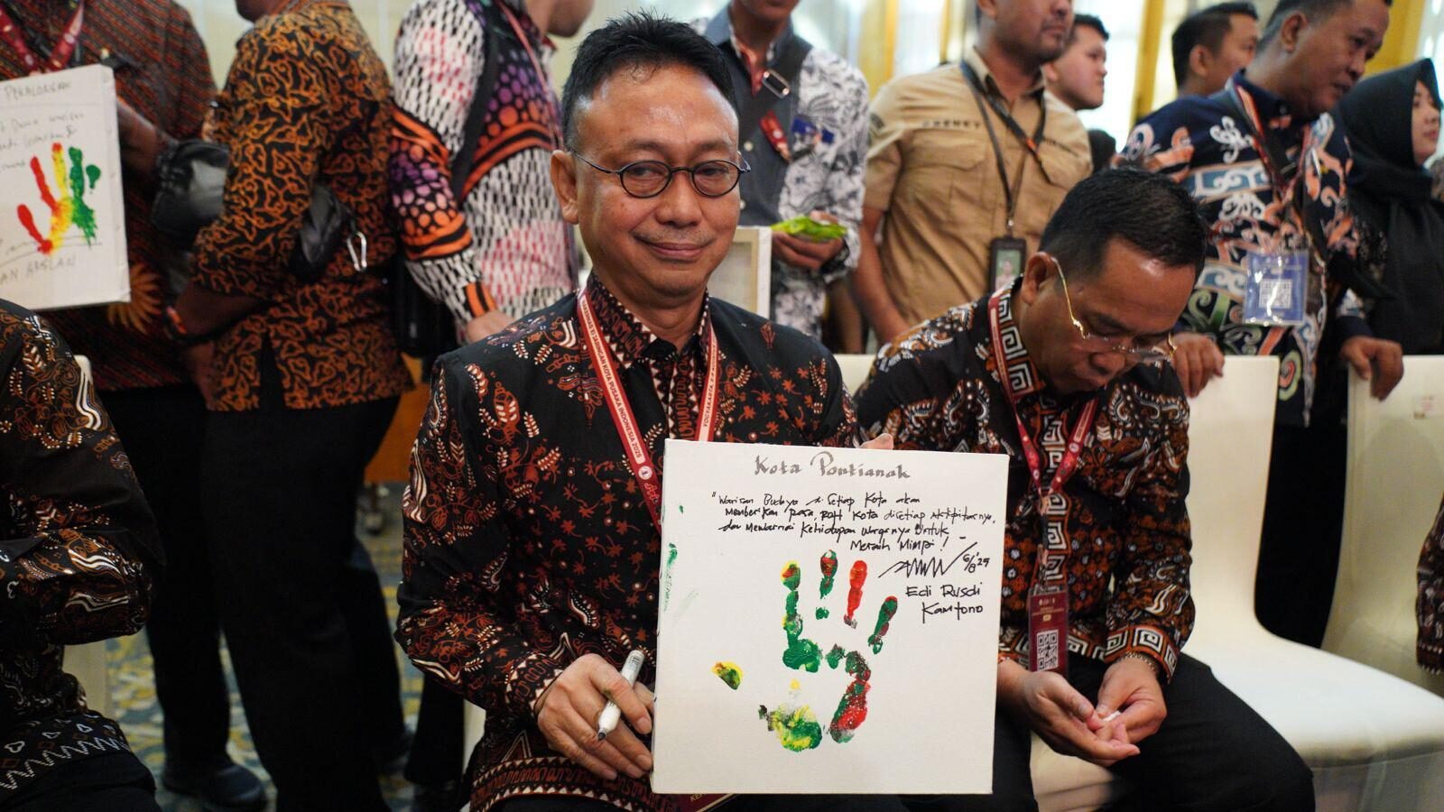 Wali Kota Pontianak Edi Rusdi Kamtono memperlihatkan pesan yang ditulis di atas kertas lukisan telapak tangannya pada Rakernas Jaringan Kota Pusaka Indonesia (JKPI) 2025.