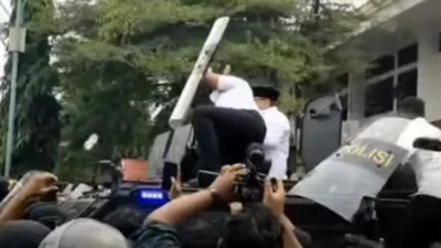 Bupati Pati, Sudewo, saat mencoba memberikan pernyataan di hadapan massa aksi dari atas mobil polisi di depan Kantor Bupati Pati, Rabu (13/8/2025).