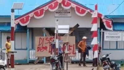 Warga Desa Nanga Kayan memasang papan segel di depan kantor desa sebagai bentuk protes atas dugaan penyelewengan dan menuntut transparansi pengelolaan dana desa.